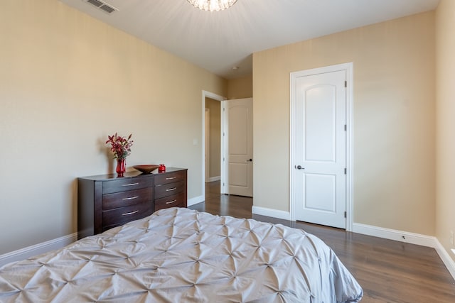 bedroom with a notable chandelier, visible vents, baseboards, and dark wood-style flooring
