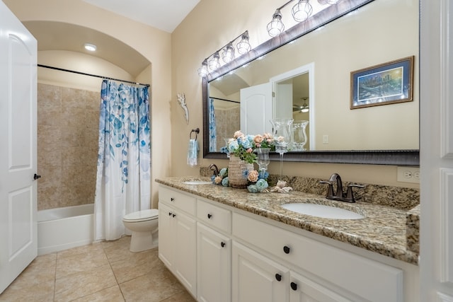 bathroom featuring a sink, shower / bathtub combination with curtain, double vanity, toilet, and tile patterned flooring