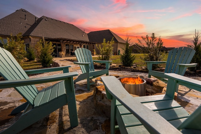 patio terrace at dusk featuring a fire pit