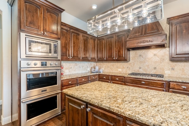 kitchen featuring stainless steel appliances, custom exhaust hood, light stone counters, and tasteful backsplash