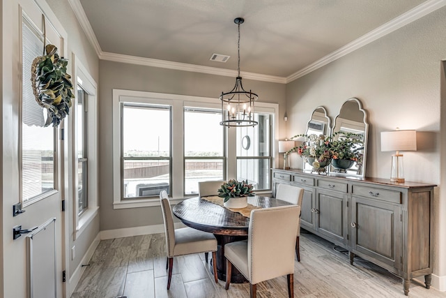 dining area featuring a notable chandelier, baseboards, visible vents, light wood-style floors, and ornamental molding