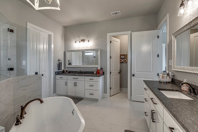 bathroom with a sink, marble finish floor, visible vents, and a soaking tub