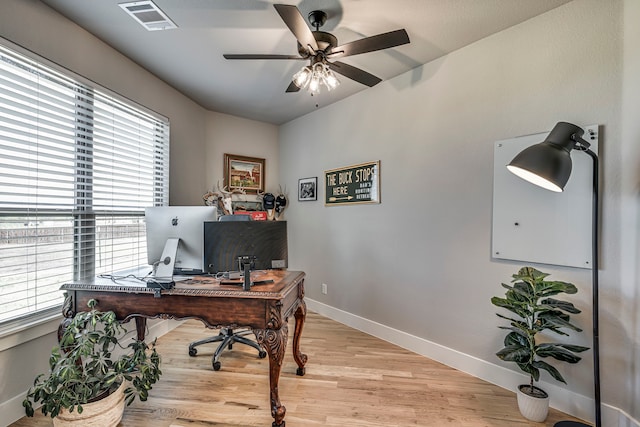office with light wood-type flooring, baseboards, visible vents, and a ceiling fan