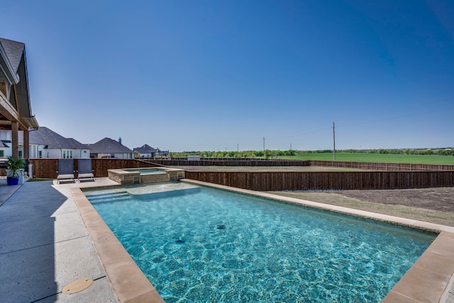 view of pool with a fenced backyard, a pool with connected hot tub, and a patio