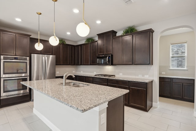 9814 Gristmill Ln, Frisco, TX 75035 - kitchen featuring a warming drawer, appliances with stainless steel finishes, dark brown cabinetry, and a sink
