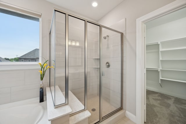 9814 Gristmill Ln, Frisco, TX 75035 - full bath featuring a bath, baseboards, a spacious closet, and a stall shower