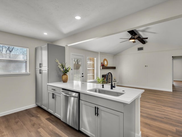 kitchen featuring a sink, a peninsula, dishwasher, and gray cabinetry