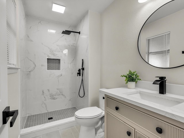 bathroom with a marble finish shower, vanity, and toilet