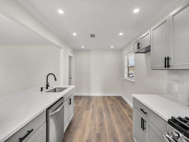 kitchen with visible vents, light stone countertops, recessed lighting, a sink, and stainless steel appliances