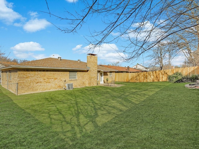 view of yard with central AC unit and fence