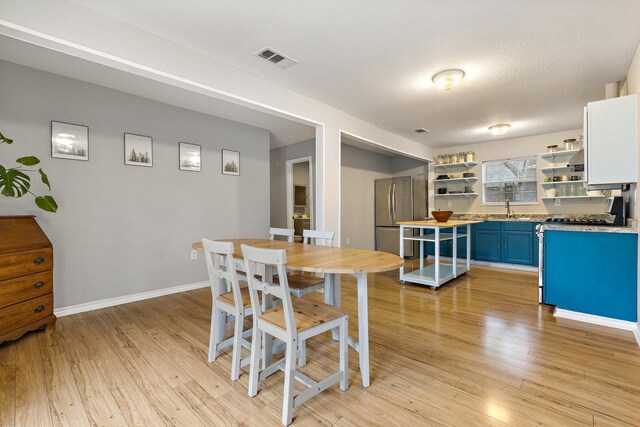 4131 Odessa St, Dallas, TX 75212 - dining space with baseboards, a textured ceiling, visible vents, and light wood-style floors