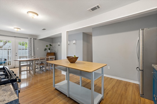 4131 Odessa St, Dallas, TX 75212 - dining area featuring visible vents, light wood-style floors, french doors, and a textured ceiling