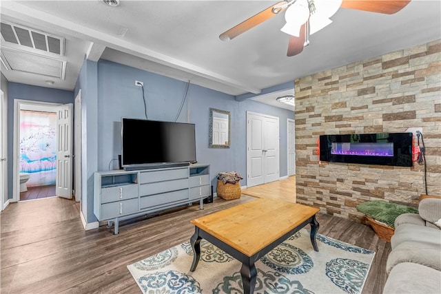 4520 Hiland Dr, Beverly Hills, TX 76711 - living area with visible vents, baseboards, wood finished floors, a ceiling fan, and a stone fireplace