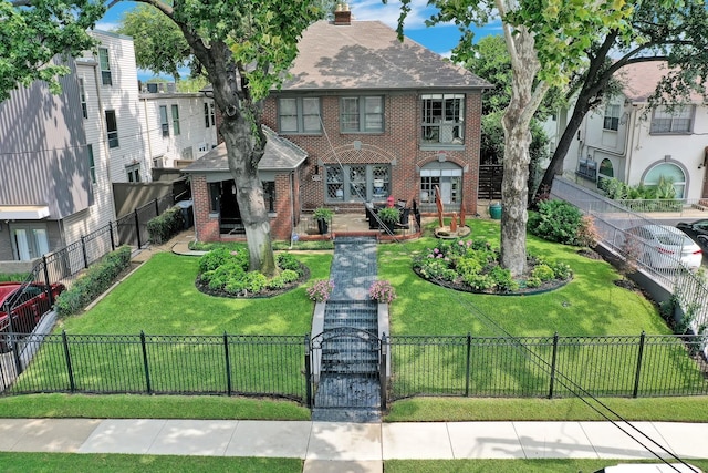 view of front facade featuring a front yard, a fenced front yard, a gate, and brick siding