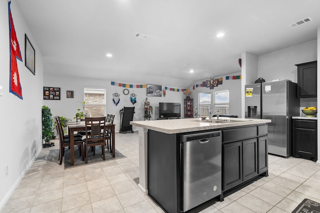 16617 Porterfield Ln, Justin, TX 76247 - kitchen featuring appliances with stainless steel finishes, a sink, light countertops, a kitchen island with sink, and dark cabinetry