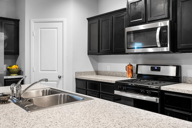 16617 Porterfield Ln, Justin, TX 76247 - kitchen with appliances with stainless steel finishes, dark cabinetry, a sink, and light countertops