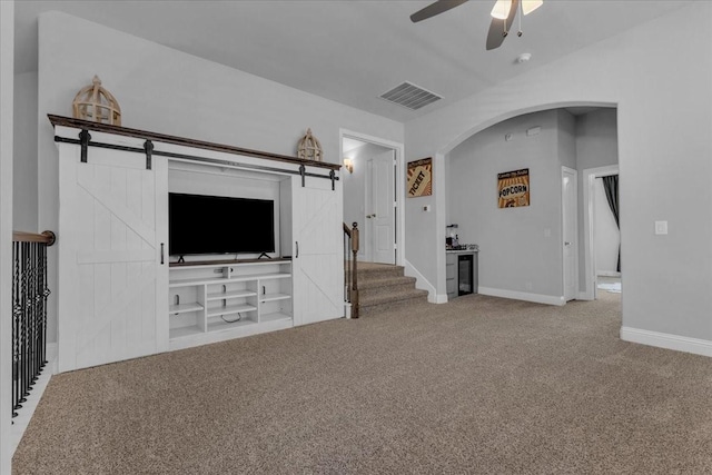7413 Windy Meadow Dr, Little Elm, TX 76227 - unfurnished living room with visible vents, arched walkways, baseboards, carpet flooring, and ceiling fan