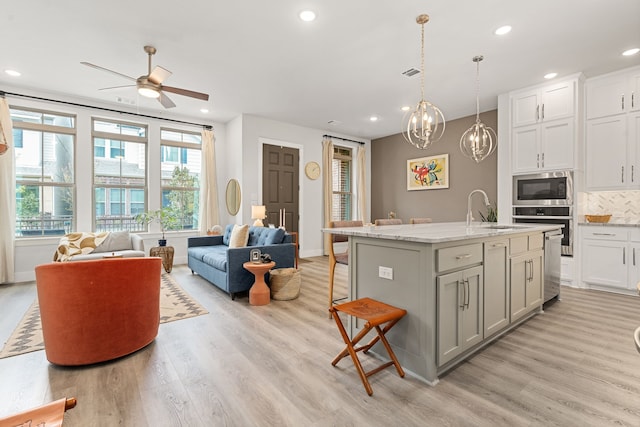 1065 Manacor Ln, Dallas, TX 75212 - kitchen with a sink, oven, built in microwave, open floor plan, and light wood-style floors