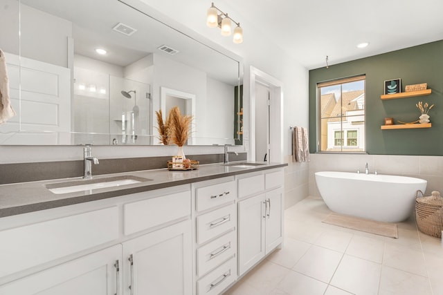 1065 Manacor Ln, Dallas, TX 75212 - bathroom featuring a stall shower, double vanity, a freestanding bath, tile patterned flooring, and tile walls