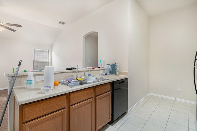 kitchen with light countertops, a sink, arched walkways, black dishwasher, and ceiling fan