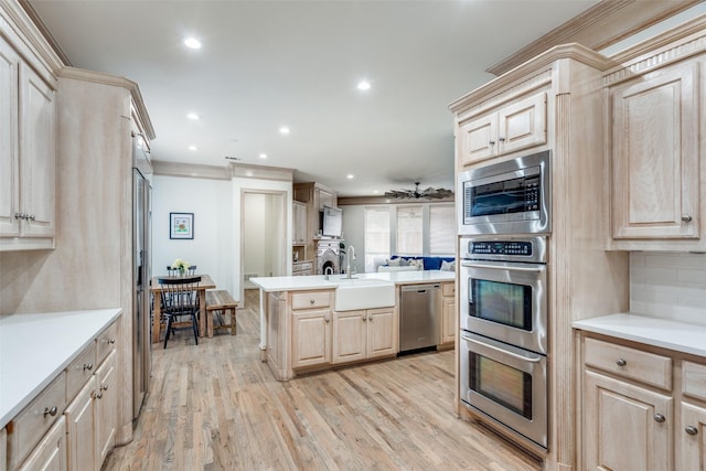 5709 Ridgehaven, Plano, TX 75093 - kitchen featuring appliances with stainless steel finishes, light brown cabinetry, a sink, light countertops, and light wood-style flooring