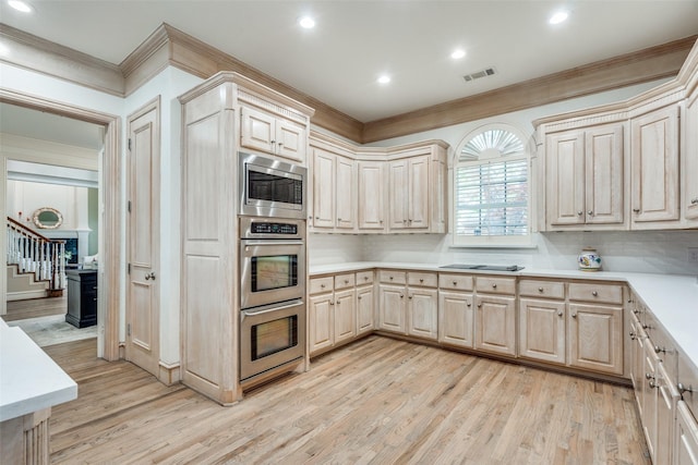 5709 Ridgehaven, Plano, TX 75093 - kitchen featuring appliances with stainless steel finishes, light countertops, crown molding, light wood finished floors, and tasteful backsplash