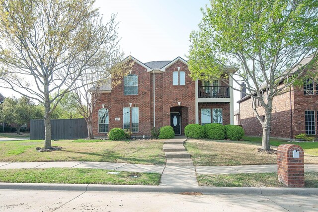 12073 Tyler Dr, Frisco, TX 75035 - view of front of home featuring a balcony, a front yard, fence, and brick siding