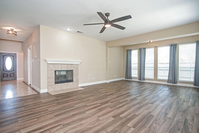 12073 Tyler Dr, Frisco, TX 75035 - unfurnished living room with ceiling fan, wood finished floors, baseboards, and a tile fireplace