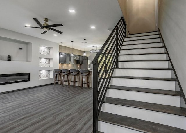 6609 Rockdale Rd, Fort Worth, TX 76134 - stairway with a ceiling fan, recessed lighting, a glass covered fireplace, and wood finished floors