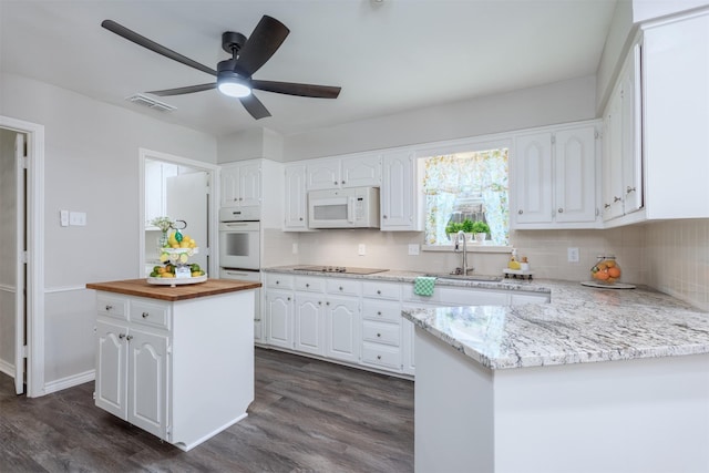 7 Harolds Cir, Richardson, TX 75081 - kitchen featuring white appliances, butcher block countertops, white cabinetry, decorative backsplash, and dark wood finished floors