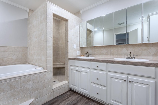 7 Harolds Cir, Richardson, TX 75081 - bathroom featuring ornamental molding, double vanity, a bath, wood finished floors, and tasteful backsplash