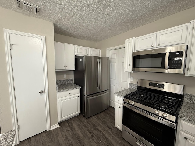 kitchen featuring dark wood finished floors, visible vents, white cabinetry, and stainless steel appliances