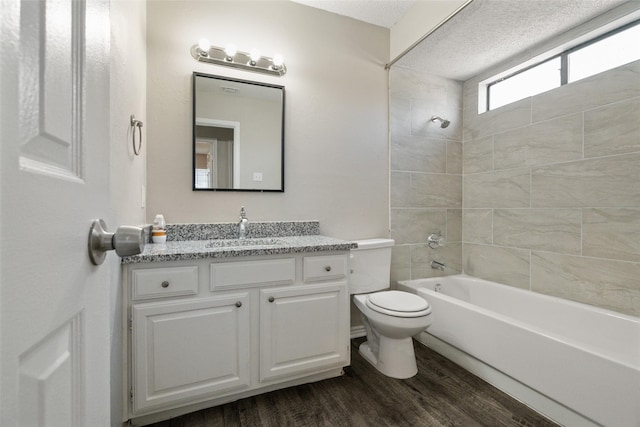 bathroom with toilet, vanity, wood finished floors, and bathing tub / shower combination