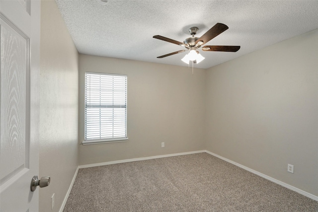 carpeted spare room featuring ceiling fan, a wealth of natural light, a textured ceiling, and baseboards