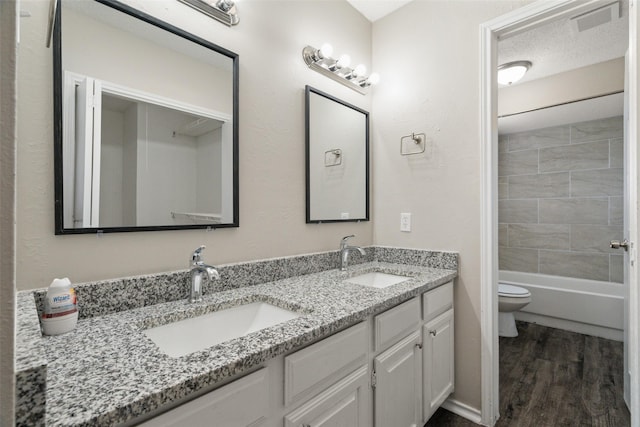 bathroom featuring visible vents, a sink, double vanity, and toilet