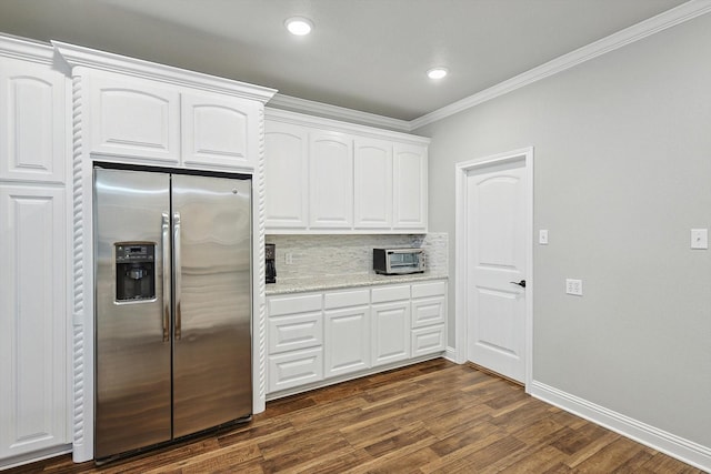 kitchen with decorative backsplash, crown molding, dark wood-type flooring, white cabinetry, and stainless steel fridge with ice dispenser