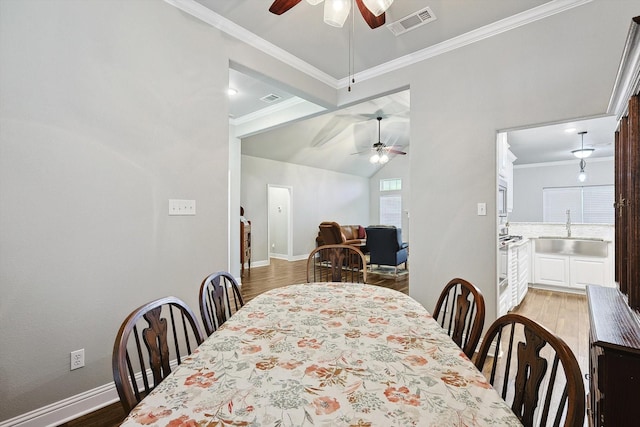 dining area with crown molding, a ceiling fan, wood finished floors, baseboards, and visible vents
