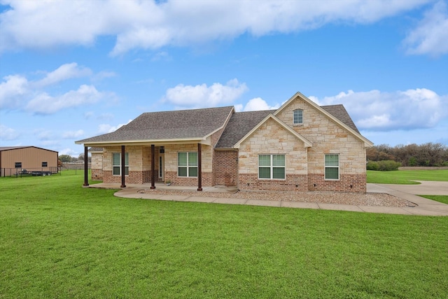view of front of home featuring stone siding, brick siding, roof with shingles, and a front lawn