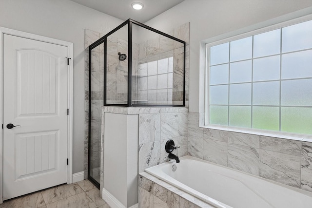 full bathroom featuring baseboards, marble finish floor, a garden tub, and a shower stall