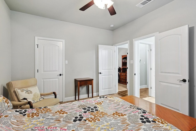 bedroom with baseboards, visible vents, light wood-style floors, and a ceiling fan