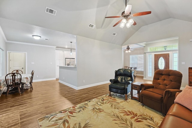 living area featuring baseboards, visible vents, light wood-style floors, and ceiling fan