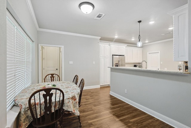 dining area with baseboards, dark wood-type flooring, crown molding, and visible vents
