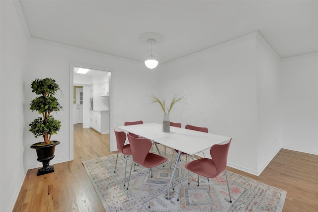 dining space featuring baseboards and light wood-style floors