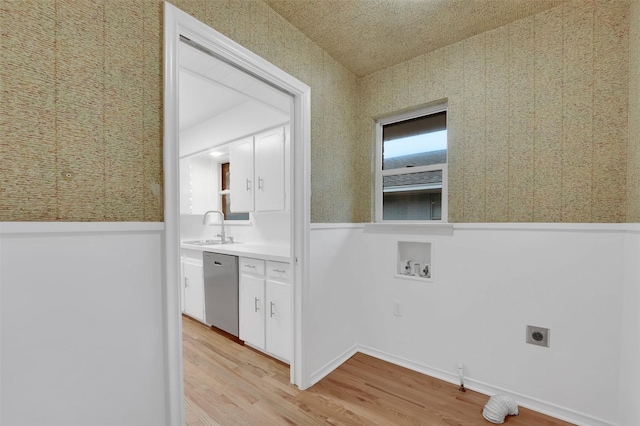 laundry room with hookup for an electric dryer, a sink, washer hookup, light wood-type flooring, and wallpapered walls