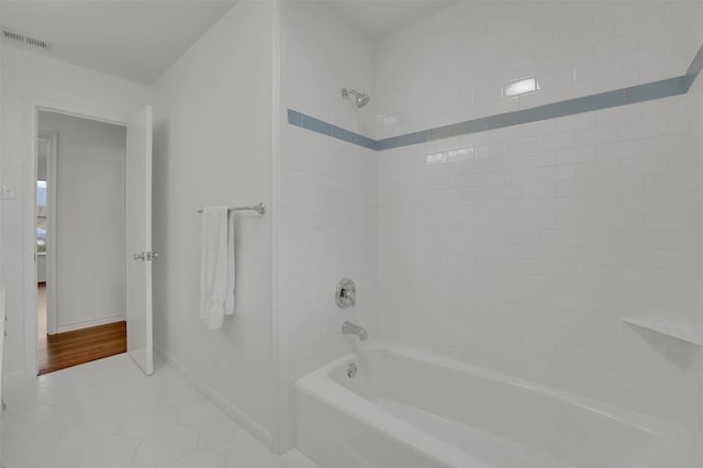 bathroom featuring tile patterned floors, visible vents, baseboards, and shower / bath combination