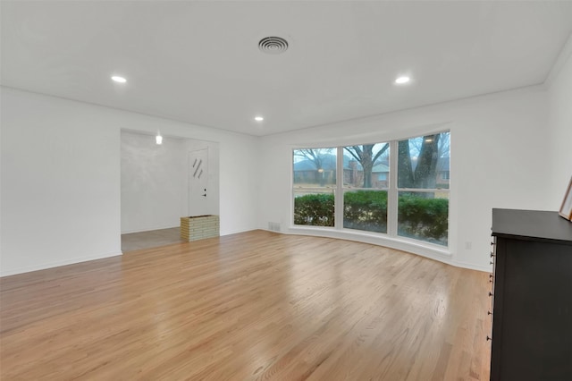 unfurnished living room featuring recessed lighting, visible vents, light wood-style flooring, and baseboards