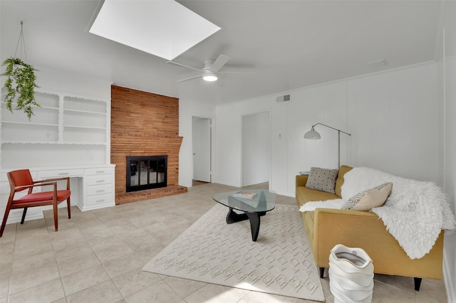 tiled living area featuring a skylight, visible vents, a ceiling fan, and a fireplace