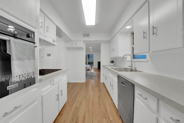kitchen with light wood finished floors, a sink, visible vents, wall oven, and dishwasher