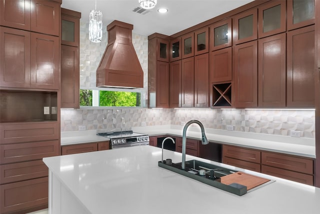 6048 Vz County Rd Unit 2120, Wills Point, TX 75169 - kitchen with stainless steel stove, hanging light fixtures, premium range hood, brown cabinets, and decorative backsplash