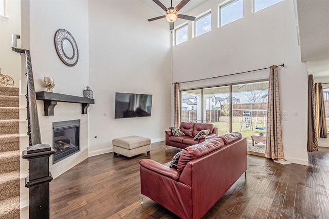 living area with dark wood finished floors, plenty of natural light, and stairway